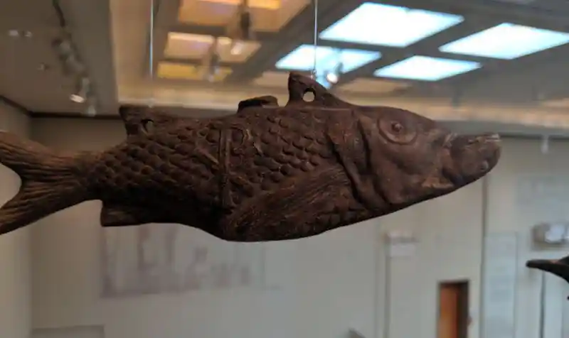Side profile of a terracotta fish-shaped hanging lamp with Christian relief symbols